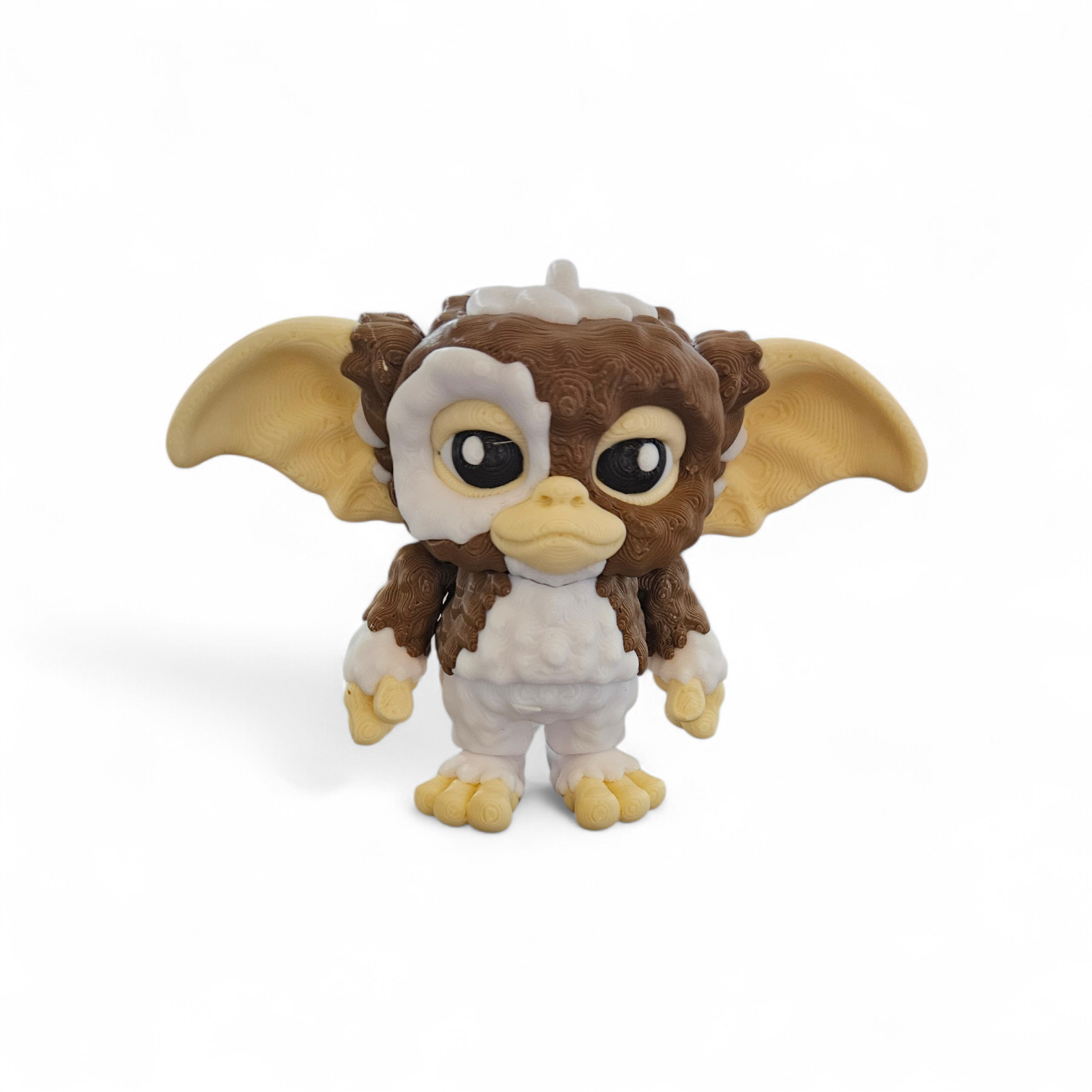A small brown-and-white Gremlin plush toy with large ears, standing on a white background.