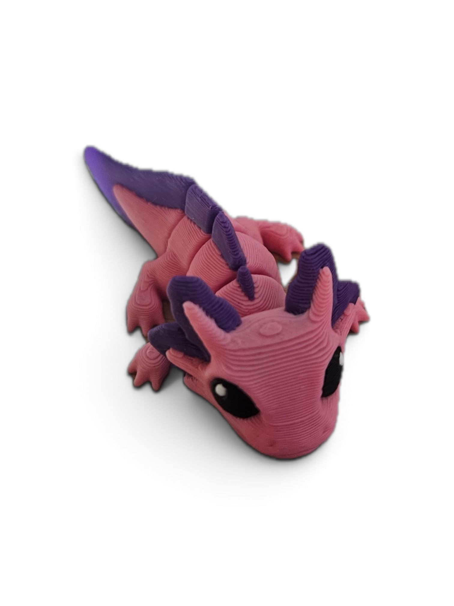 Pink and purple dragon figurine with curled tail on a white background