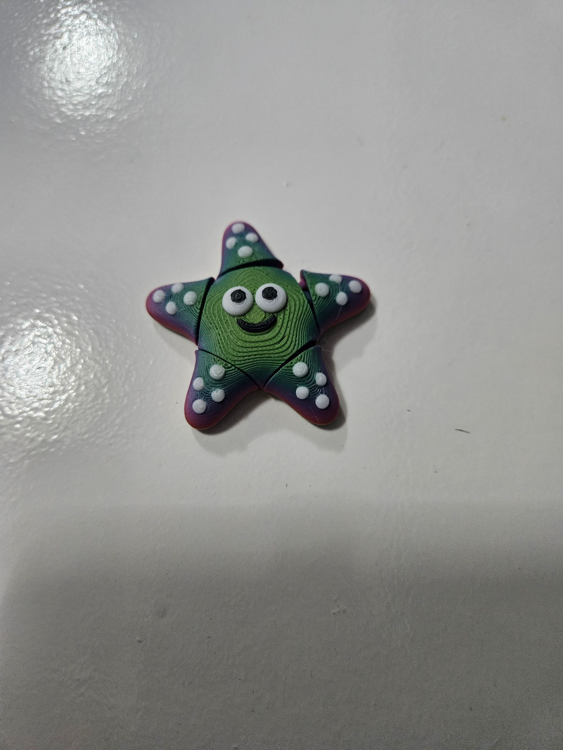 Green starfish figure with a friendly face and white polka dots.