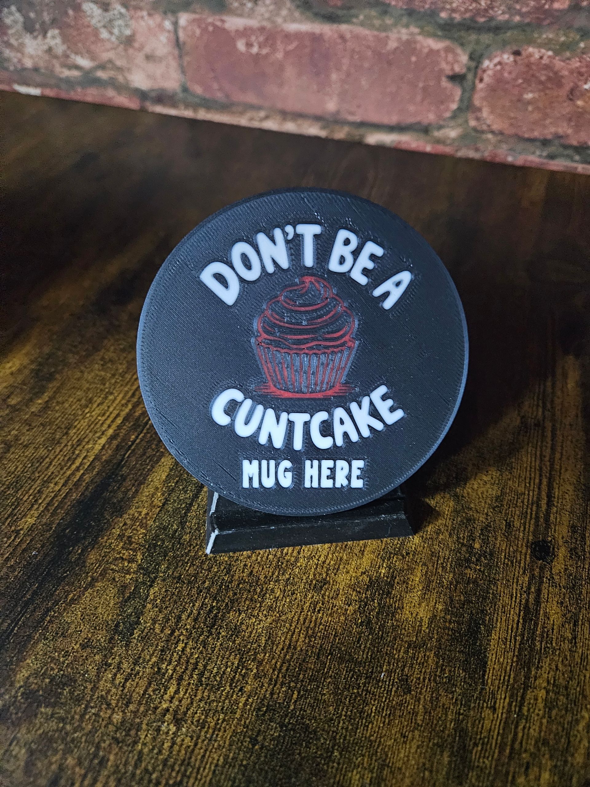 Black coaster with text: