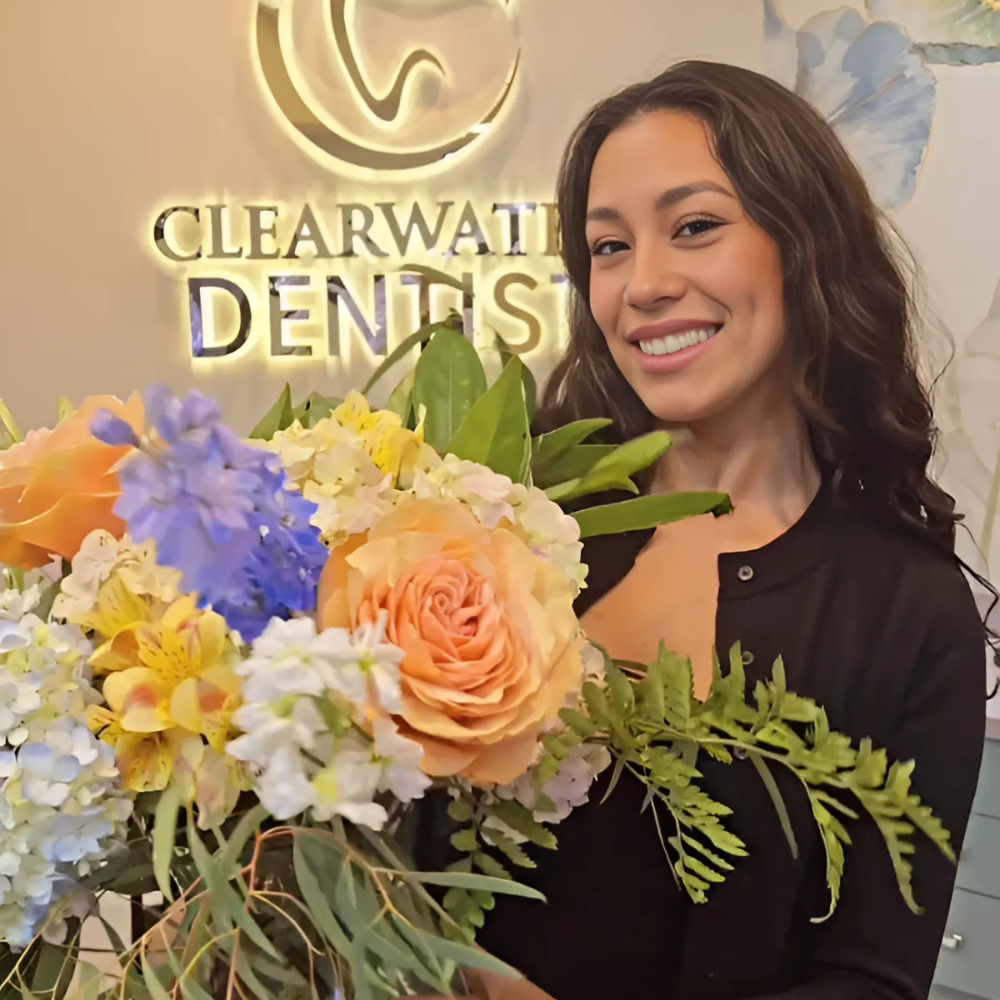 receptionist holding flowers while smiling