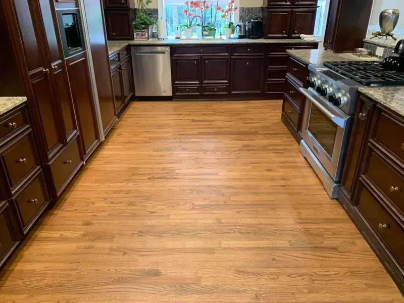 Spacious kitchen with dark wood cabinets, stainless steel appliances, and hardwood floors.