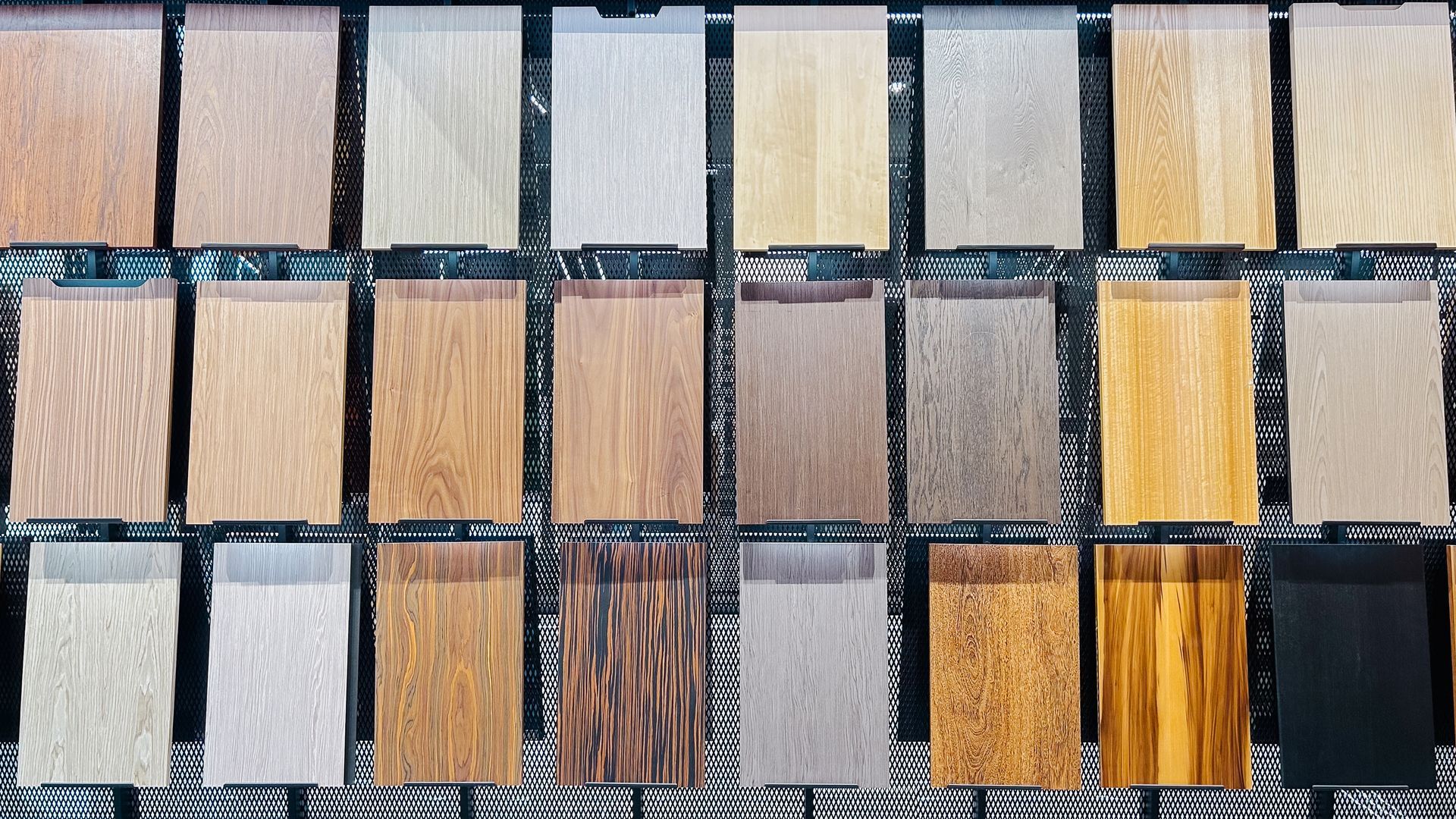 Assorted wood sample tiles arranged in rows, showing different grain patterns and stain colors.