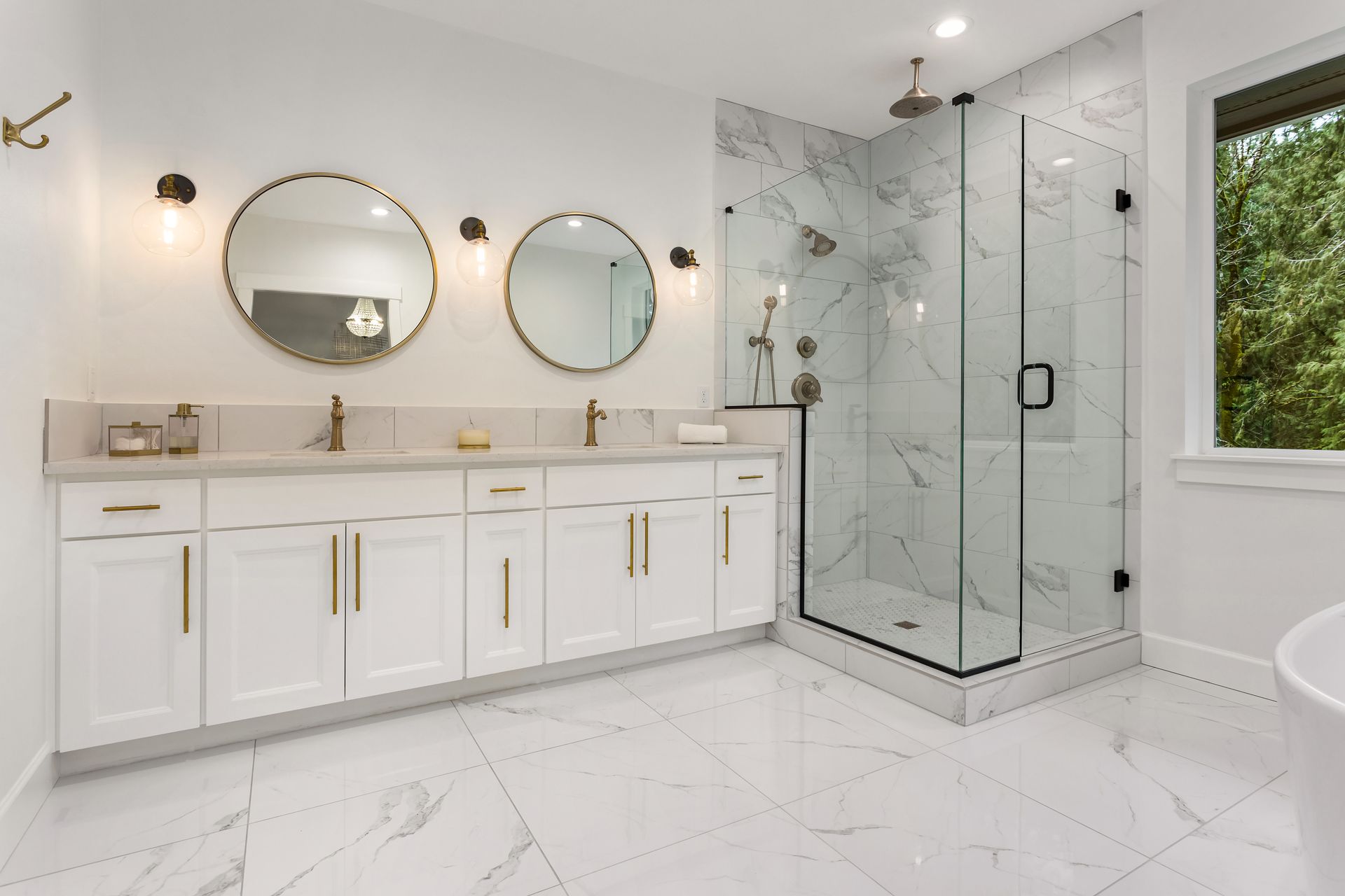 Modern white bathroom with double vanity, round mirrors, and glass walk-in shower