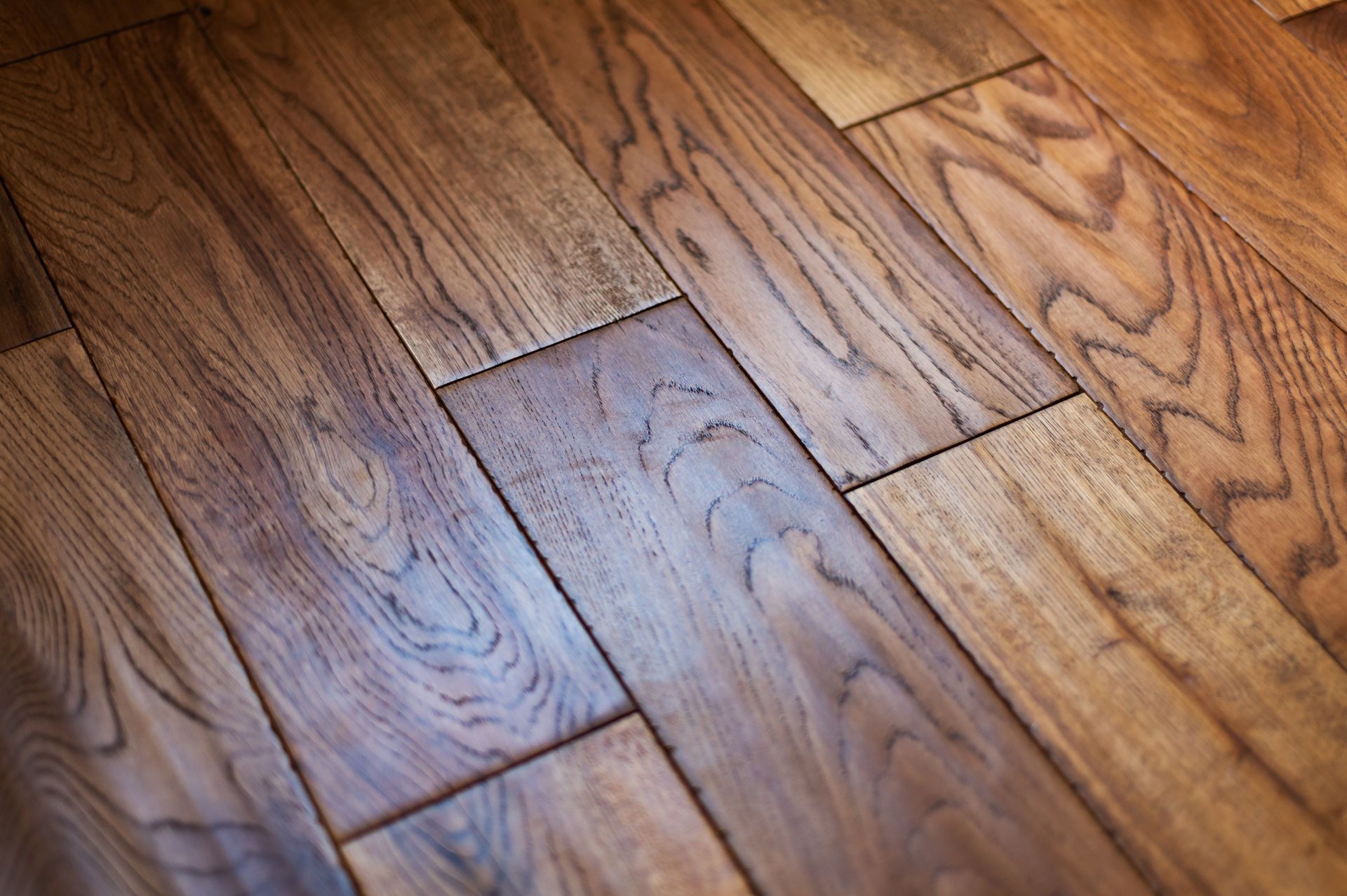 Close-up of warm-toned wooden floorboards with visible grain and staggered planks