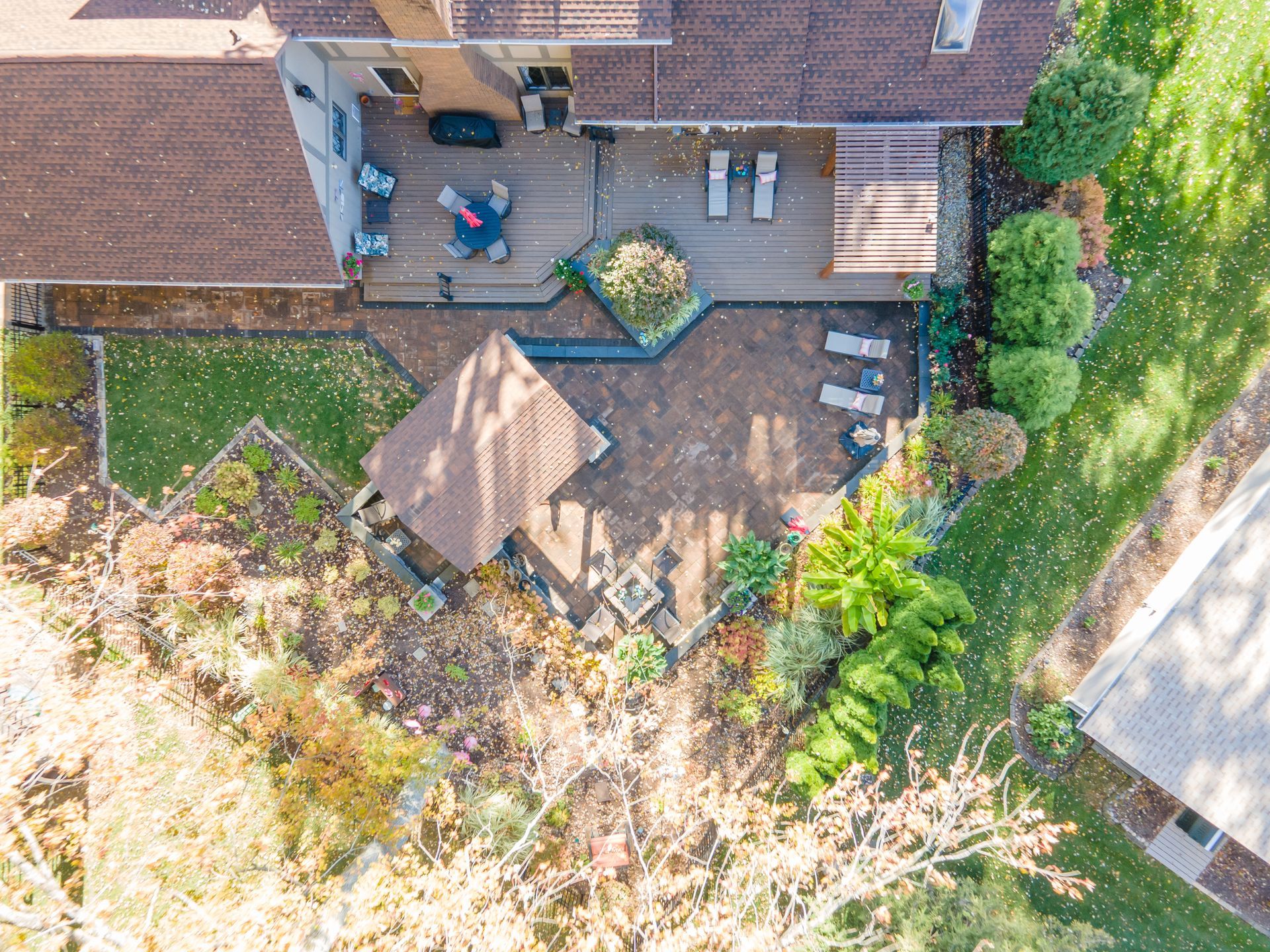 Aerial view of a home's backyard with a patio, garden, and seating areas.