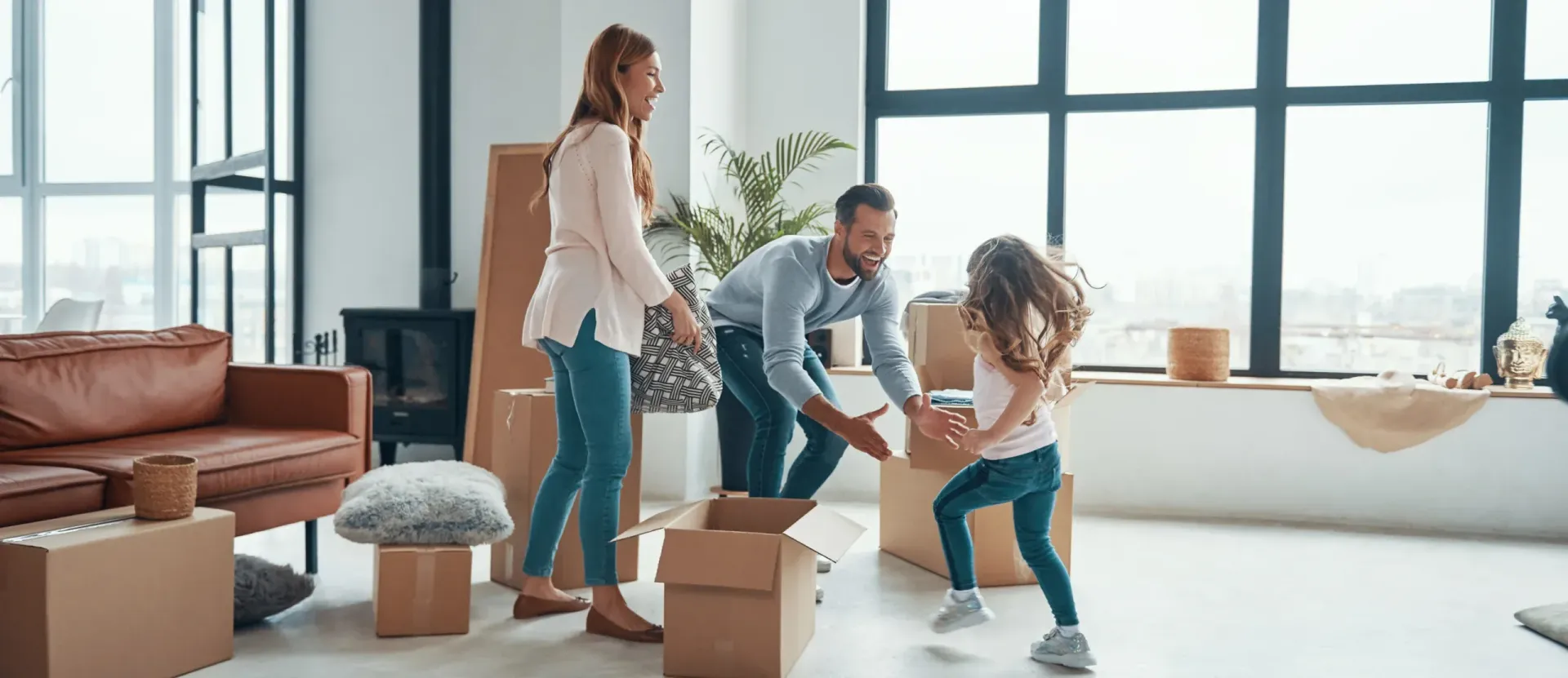 Family unpacking moving boxes in a bright living room