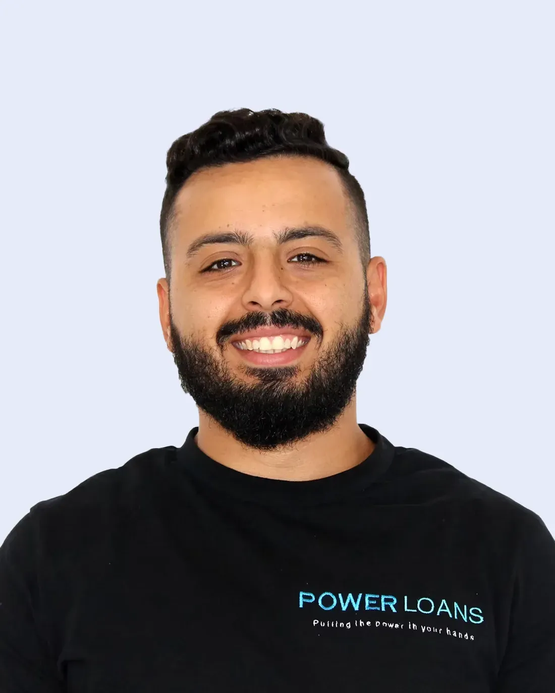 Smiling man in black Power Loans shirt against a light blue background