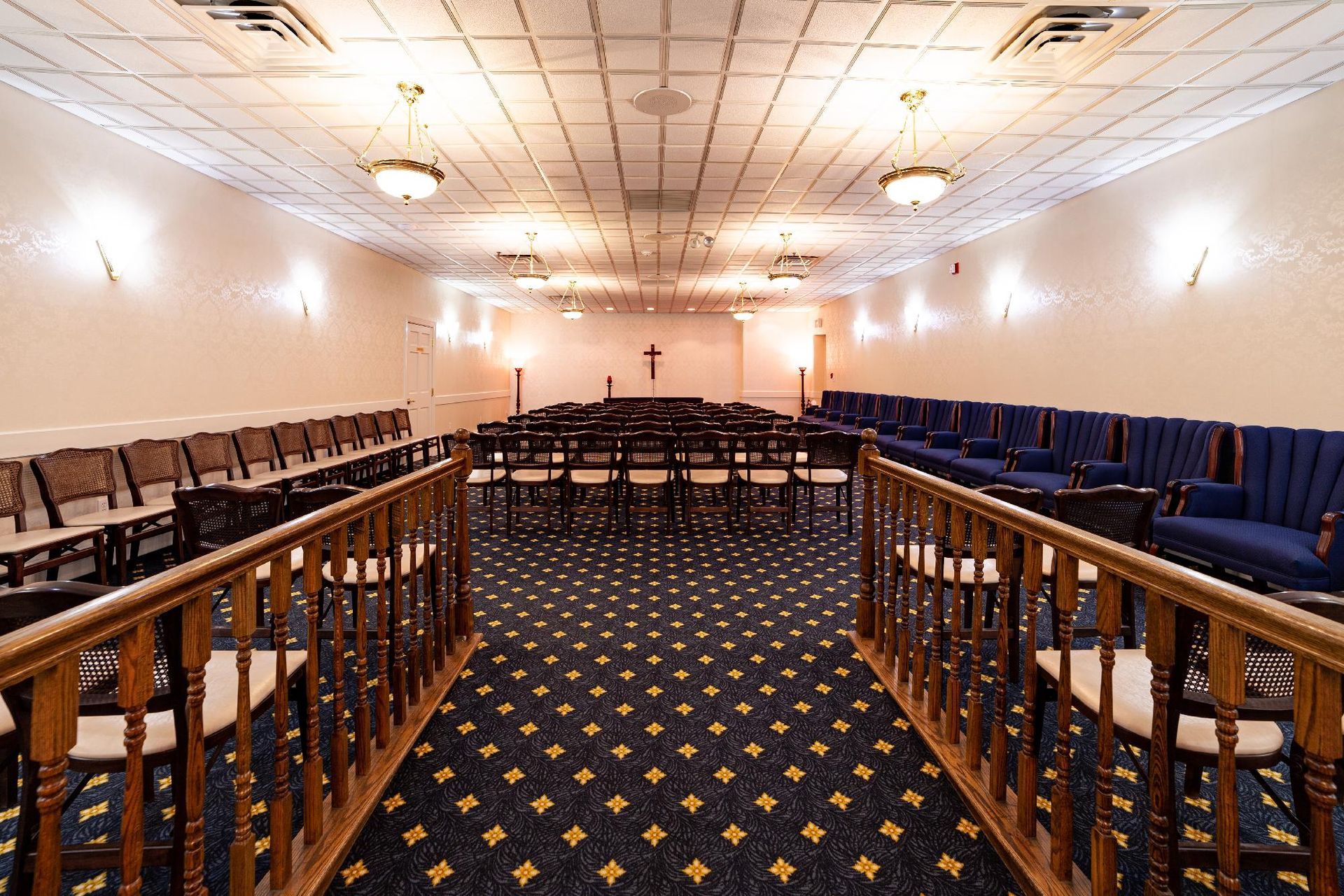 Empty conference room with rows of chairs, patterned carpet, and a lectern at the front