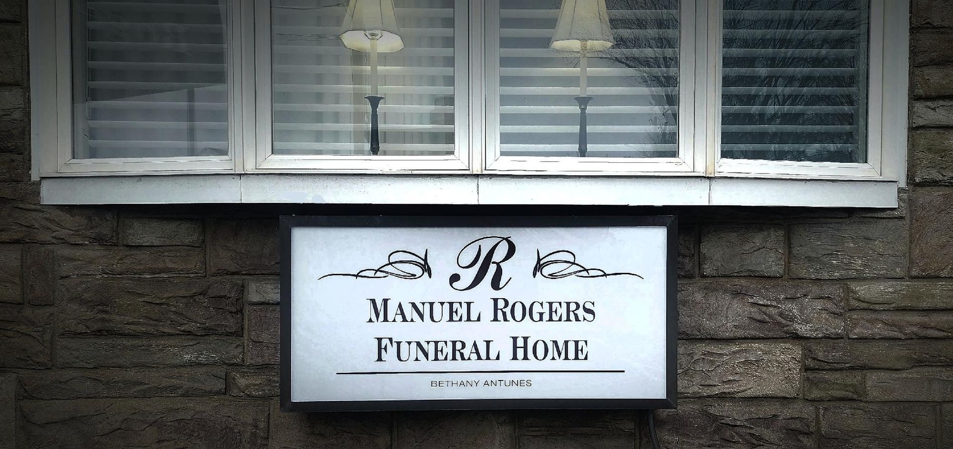 Sign on brick building reading “R. S. Manuel Rogers Funeral Home”