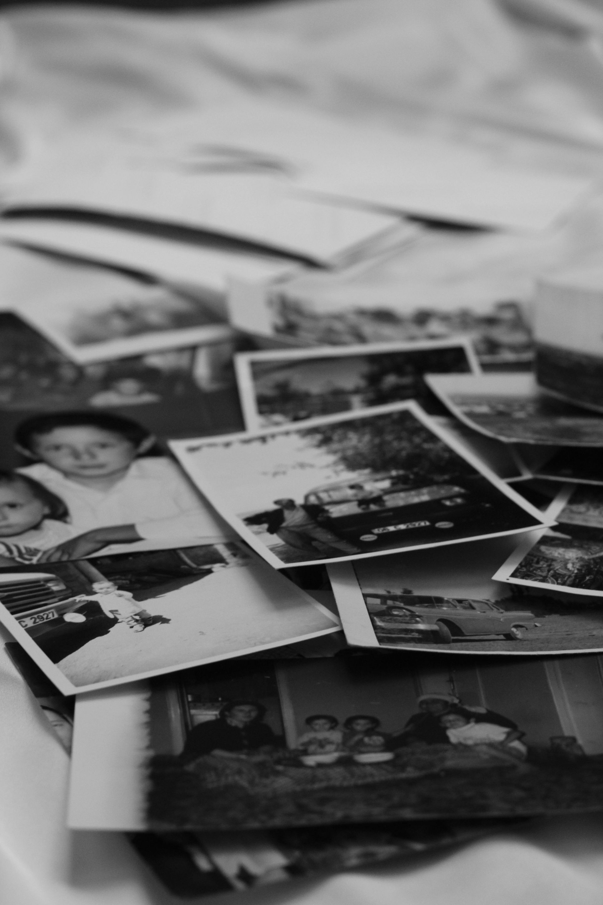 Scattered black-and-white and color photo prints laid on a table