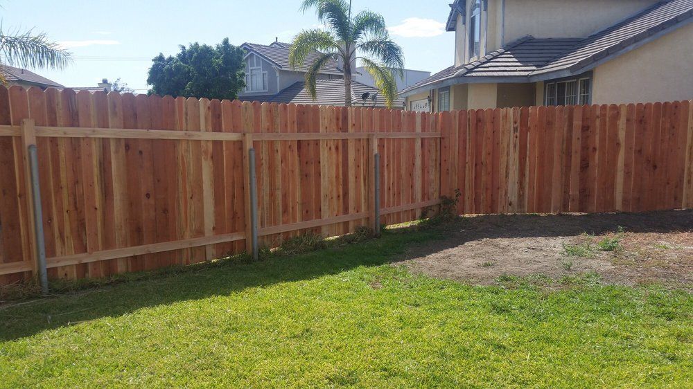 A wooden fence with a blue sky in the background.
