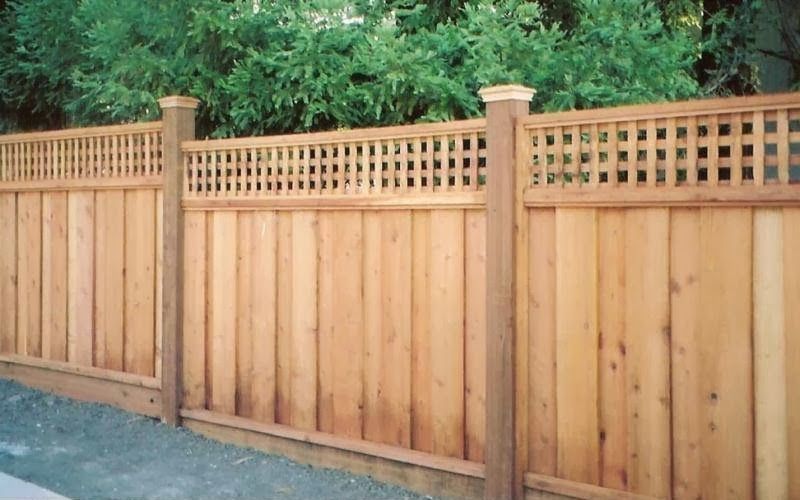 a white picket fence surrounds a lush green field .