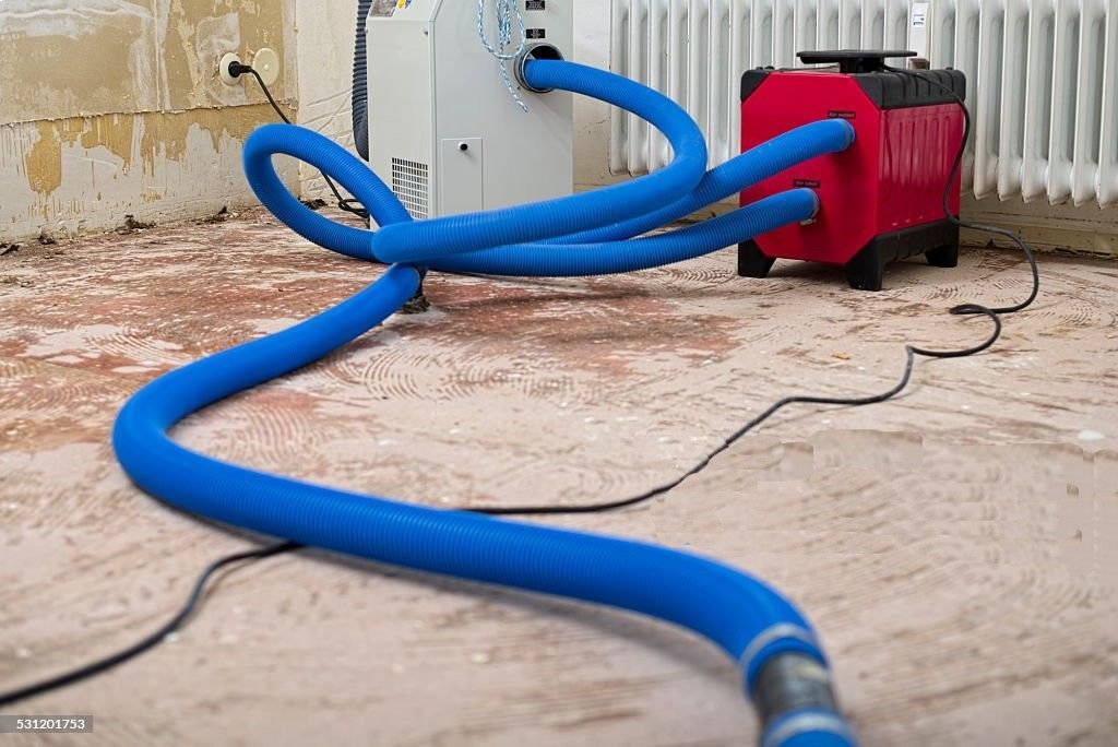 A blue hose is connected to a machine in a room.