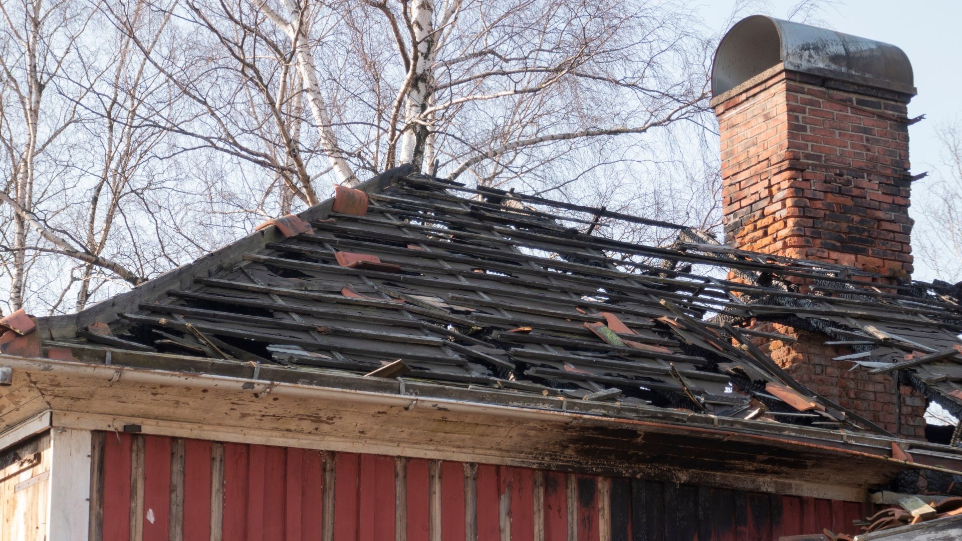 A house with a broken roof and a chimney.