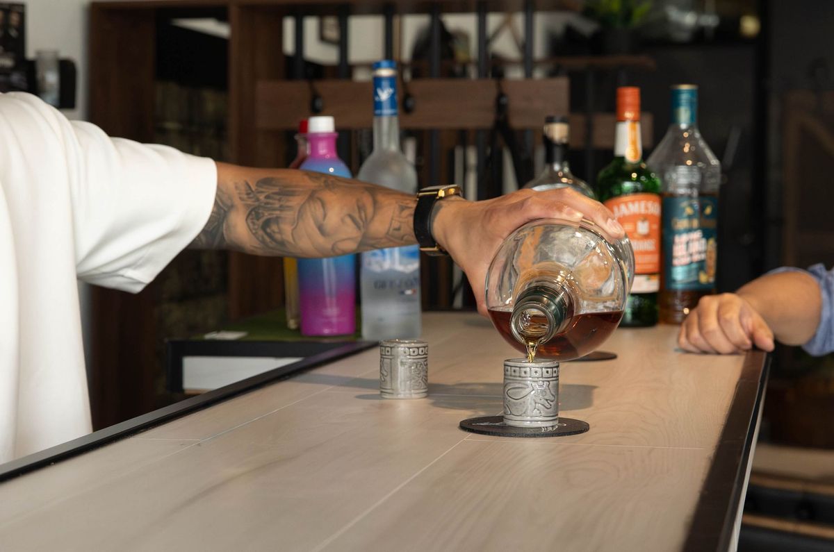 Complimentary drink being poured at the Goodfellas Barbershop bar