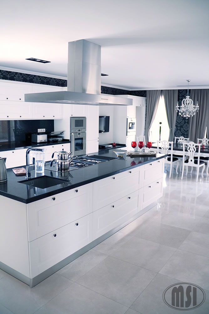 a kitchen with white cabinets and black counter tops and a msi logo in the corner
