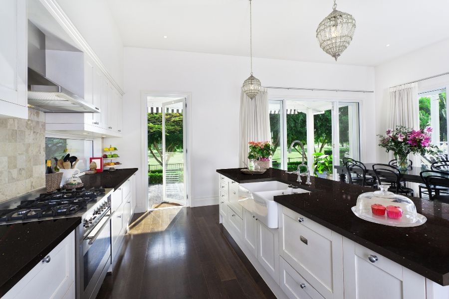 a kitchen with black counter tops and white cabinets