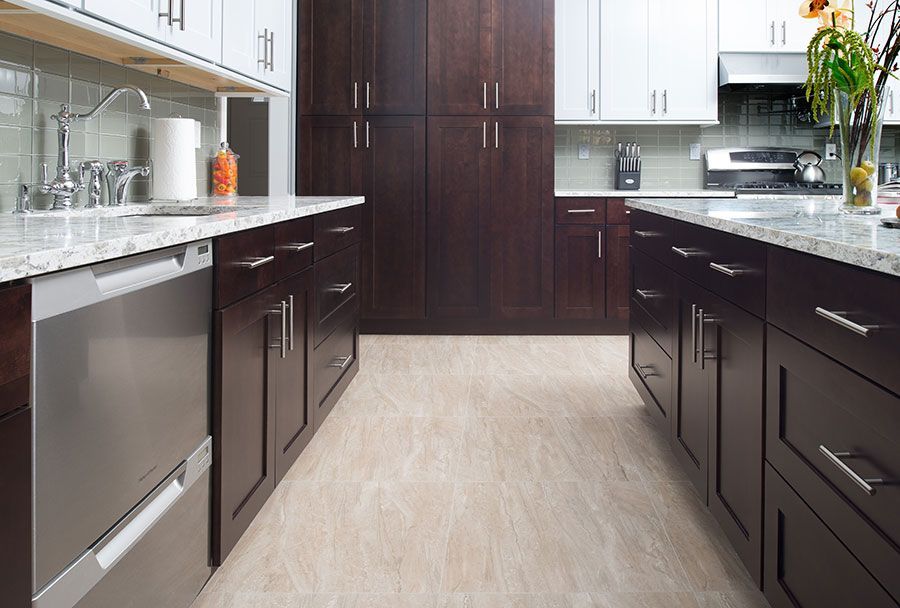 a kitchen with dark cabinets and stainless steel appliances