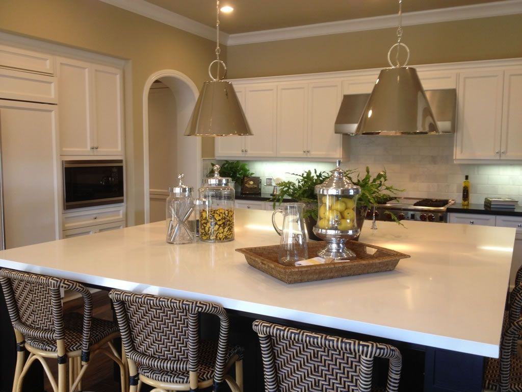 a kitchen with a large island and wicker chairs