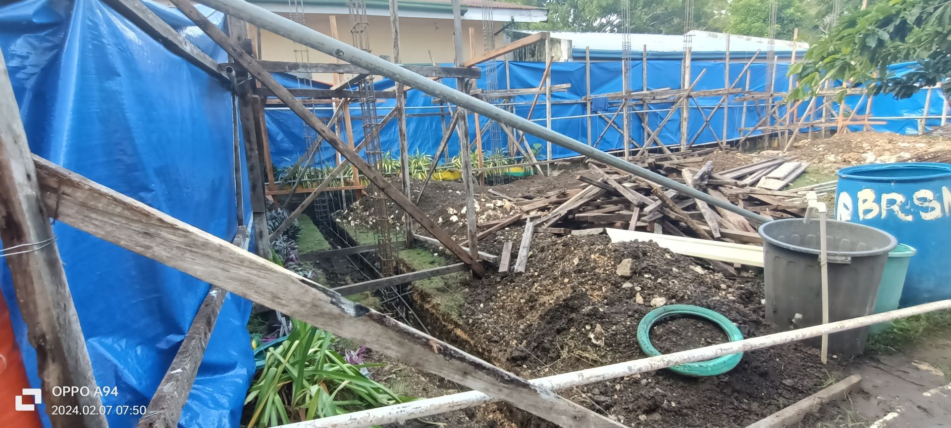 A pile of dirt is sitting in front of a building under construction.