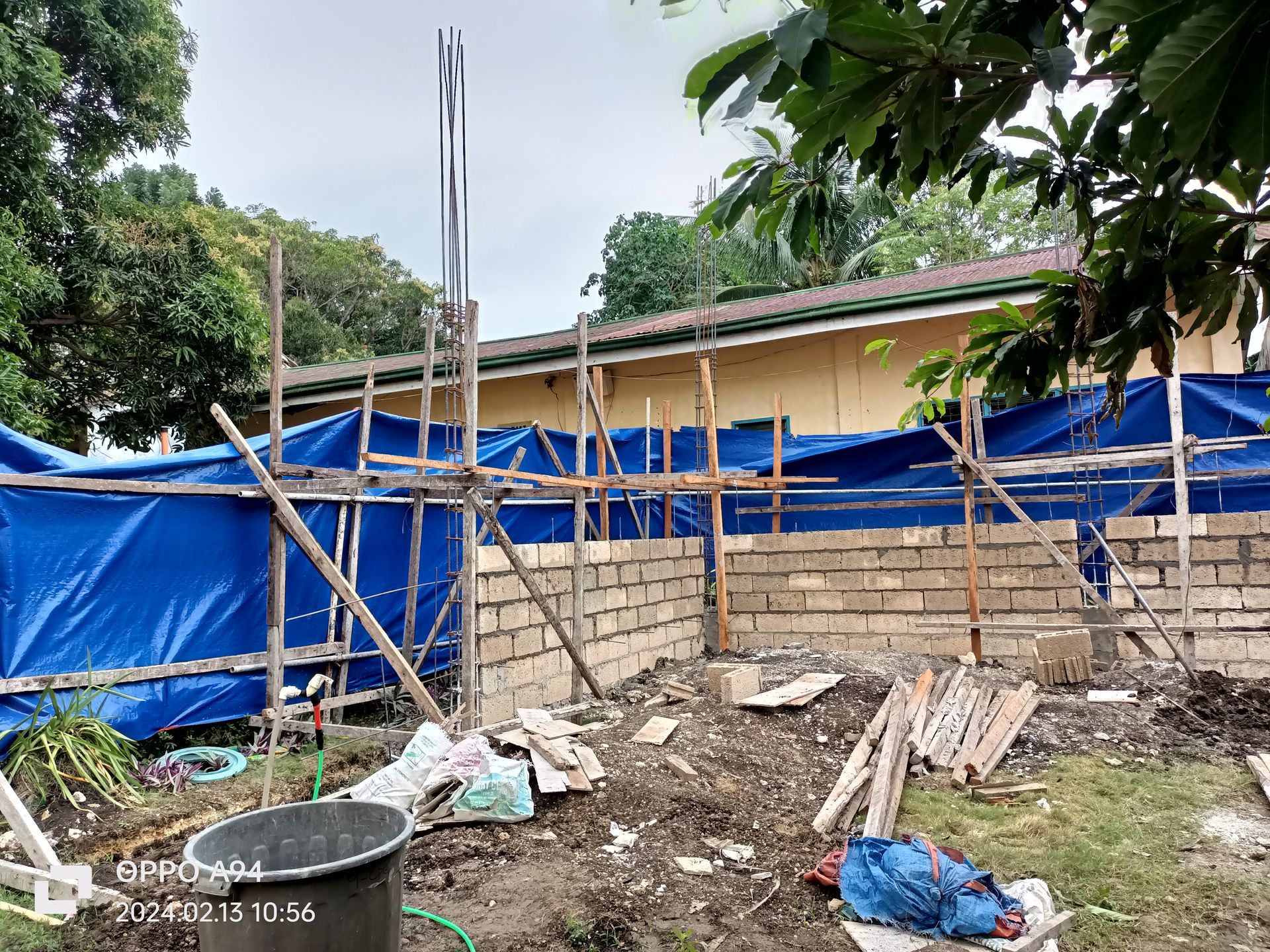 A building under construction with a blue tarp covering it.