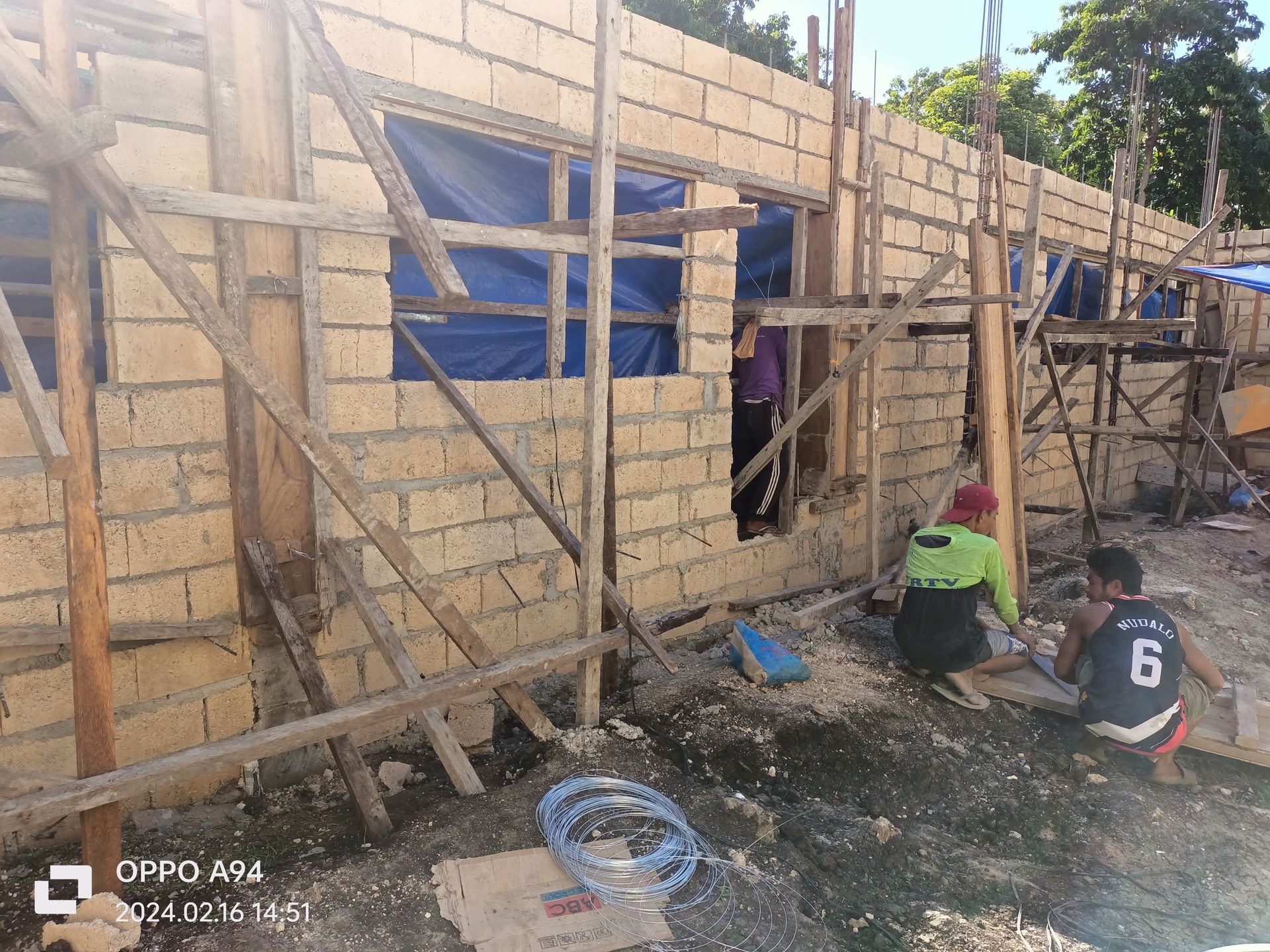A group of construction workers are working on a brick wall.