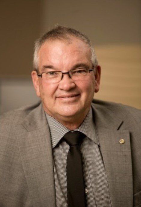 A man in a suit and tie is smiling for the camera.