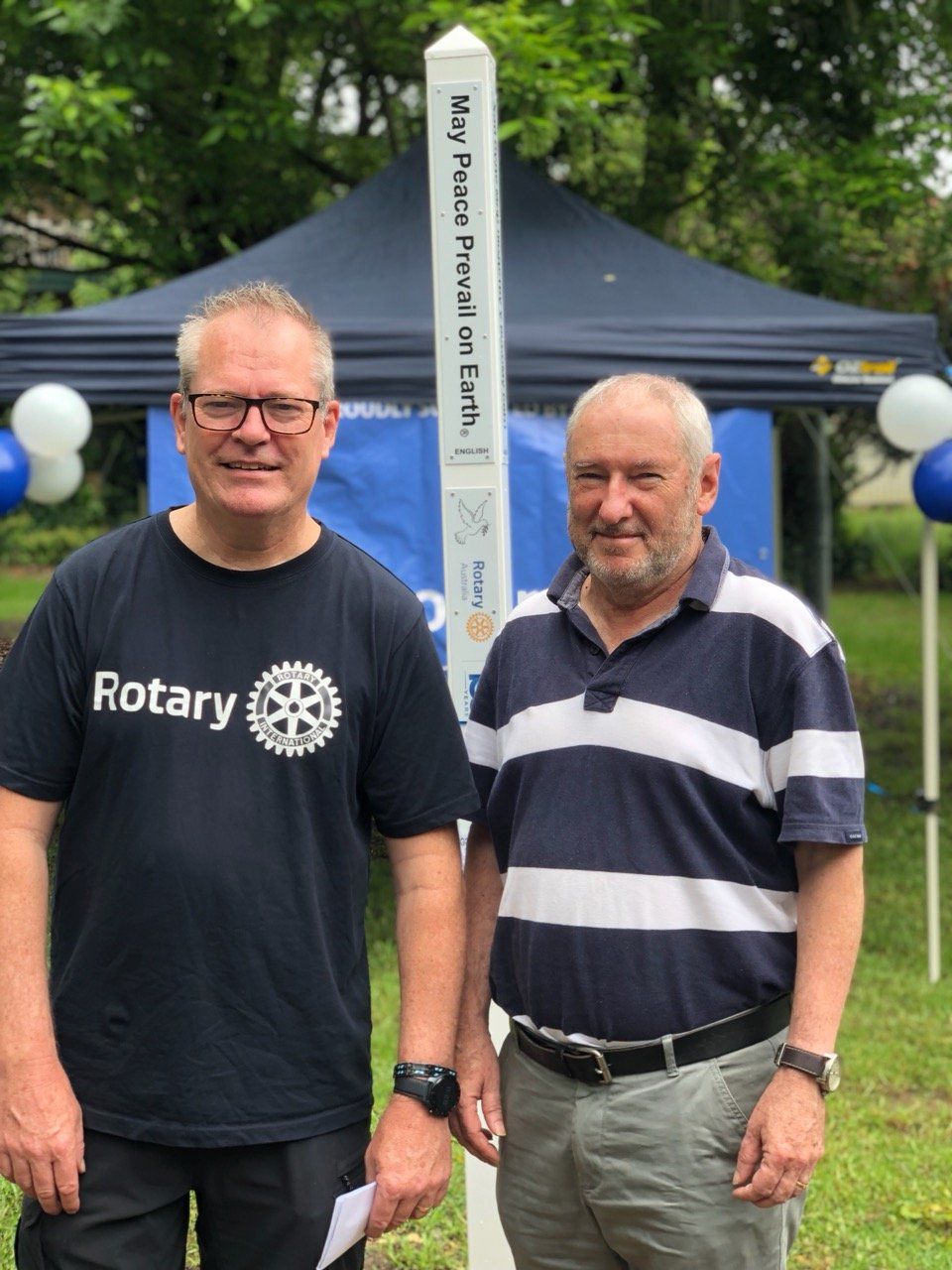 Two men standing next to each other with one wearing a rotary shirt