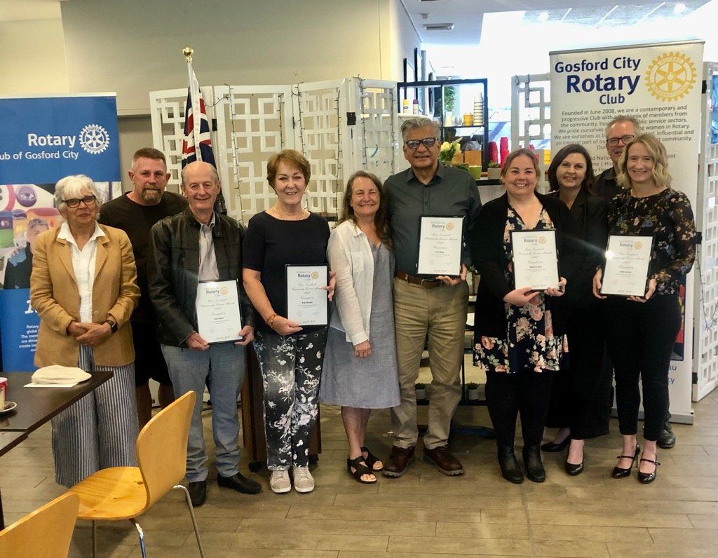 A group of people standing next to each other holding certificates.