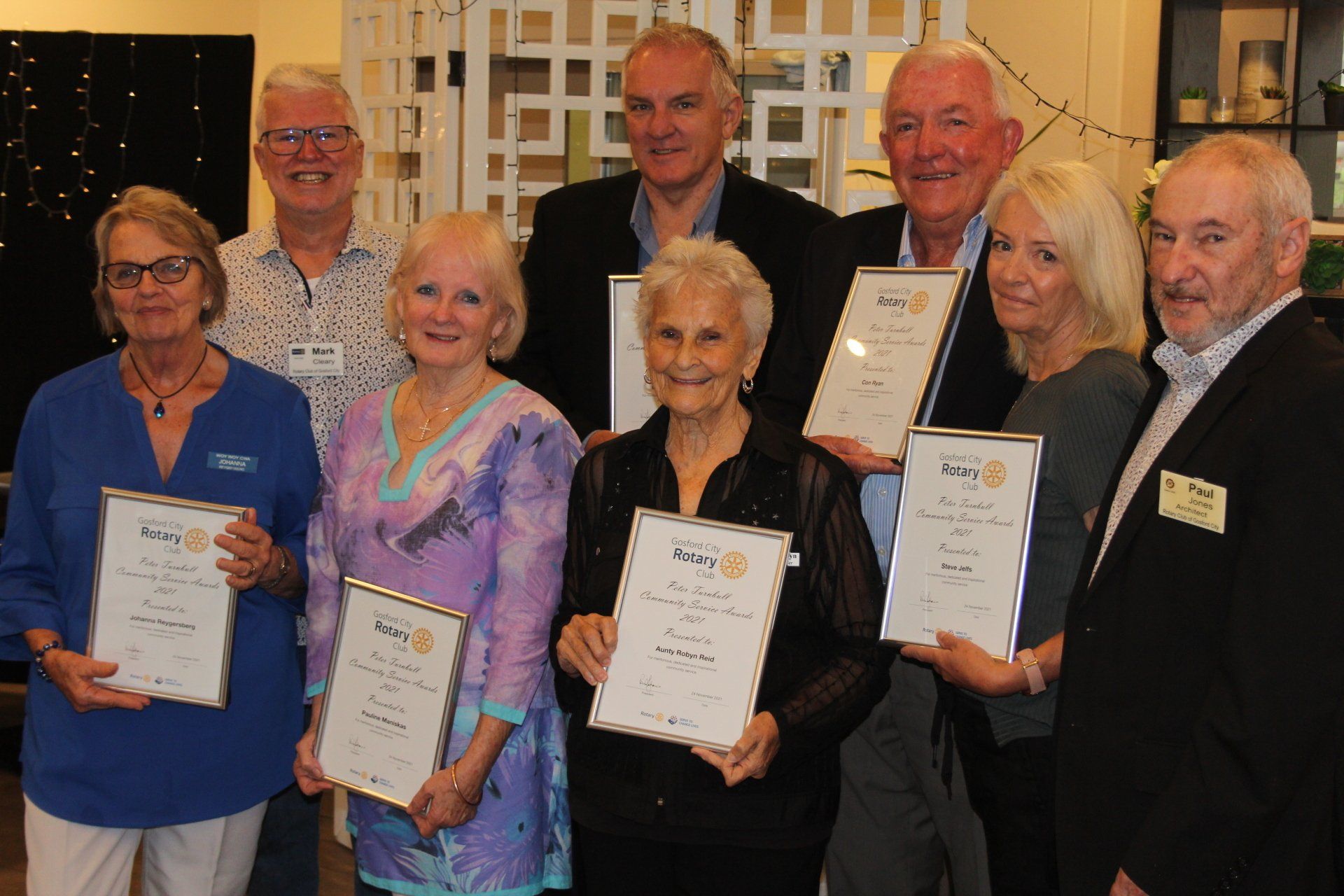 A group of people are posing for a picture while holding certificates