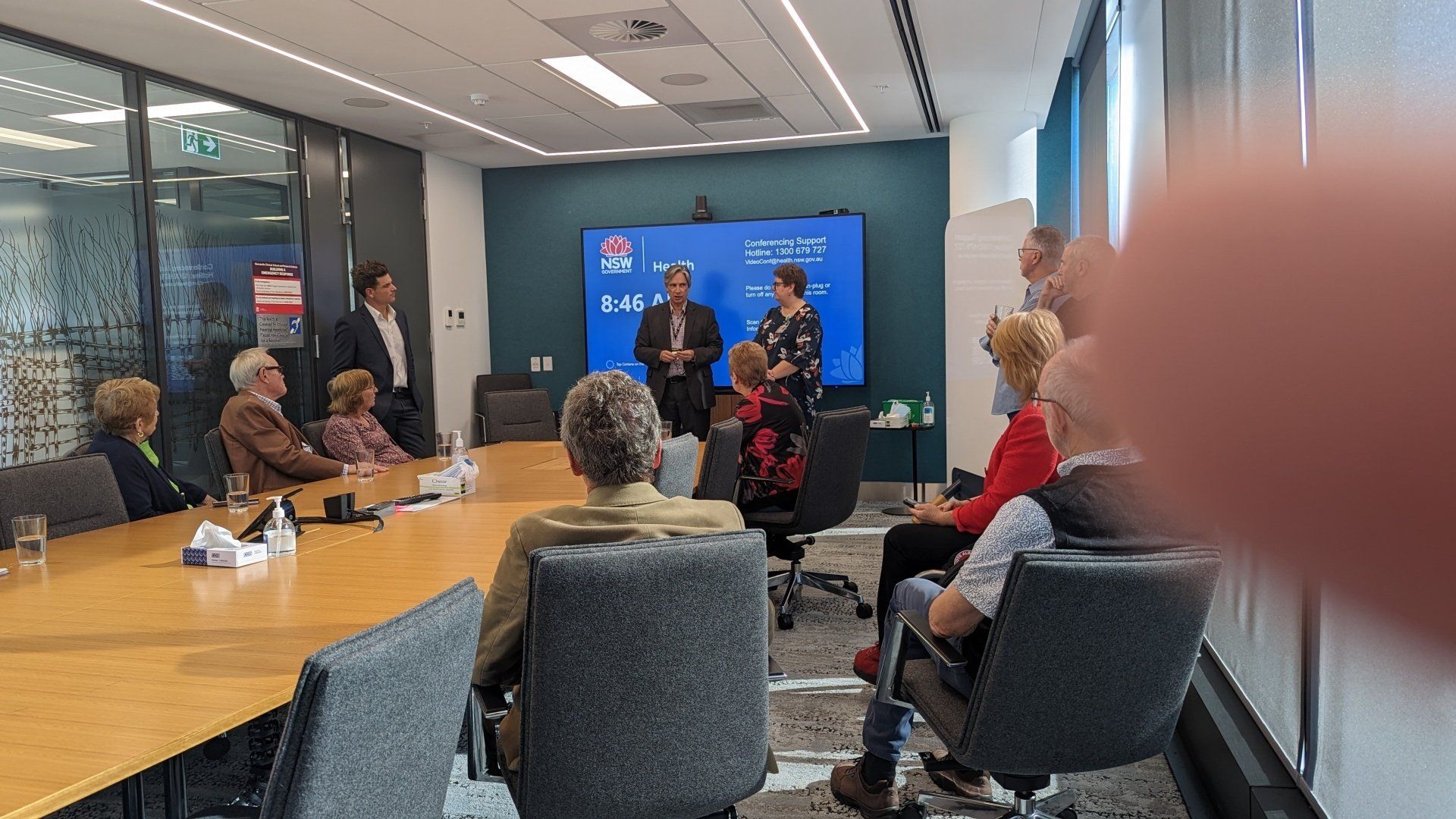 A group of people are sitting around a table in a conference room.