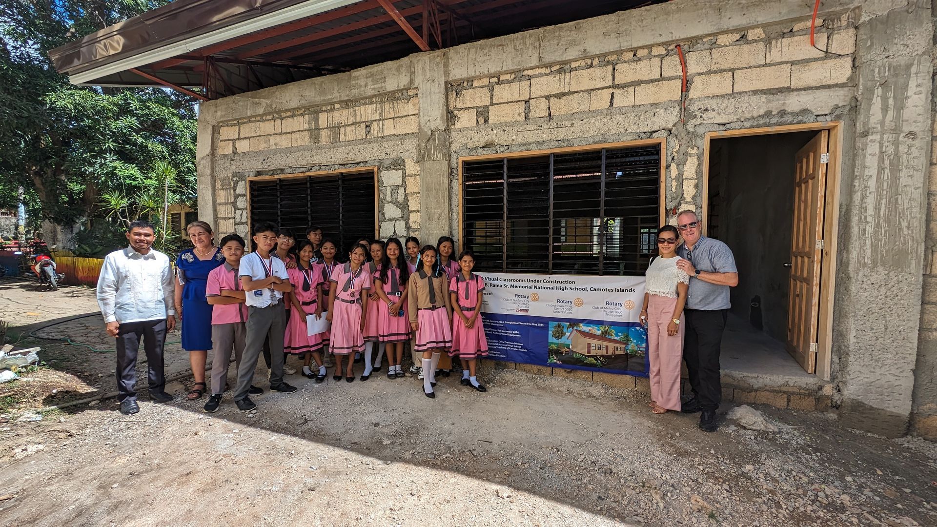 A group of people are standing in front of a building under construction.