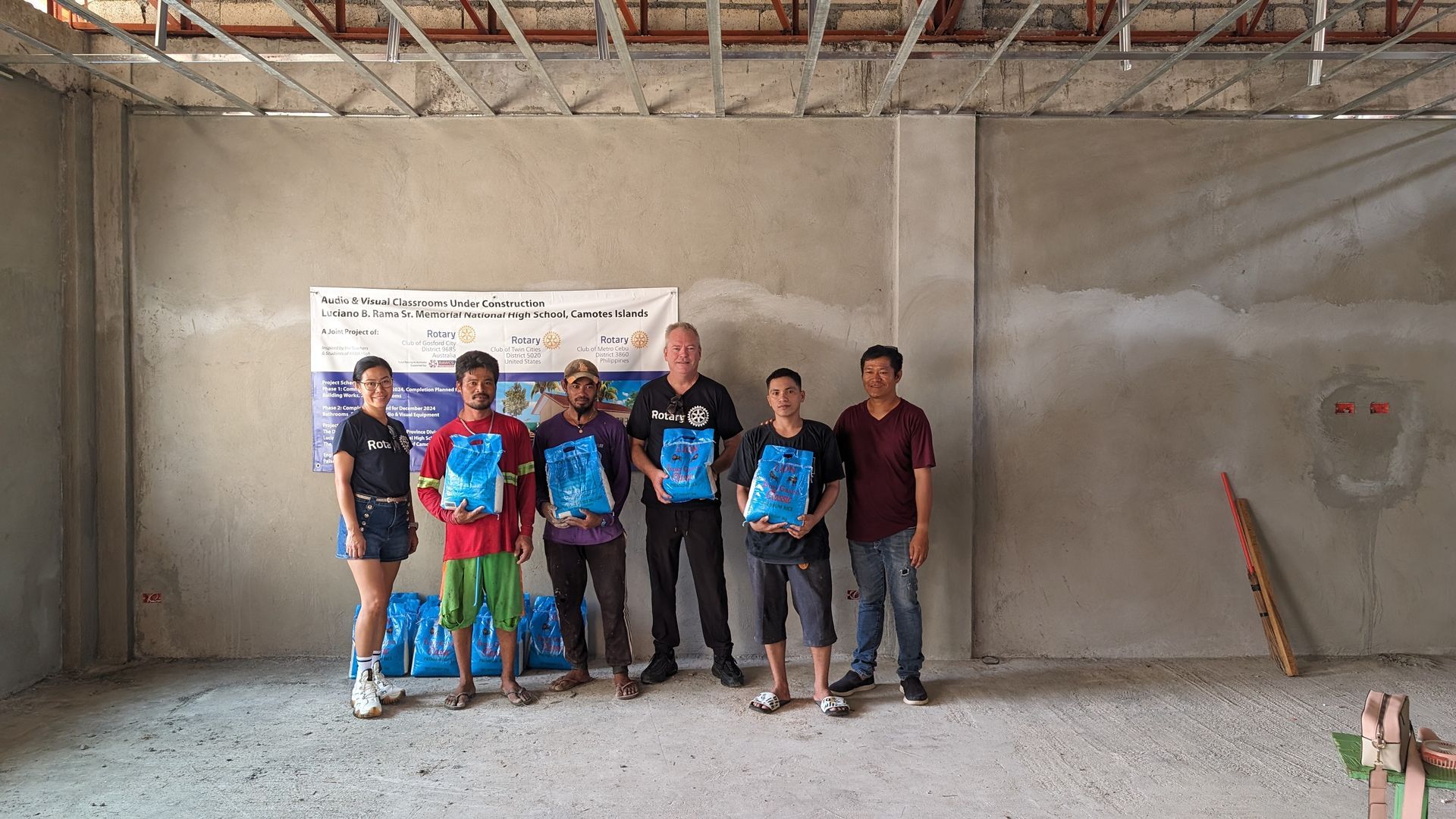 A group of people are posing for a picture in an empty room.