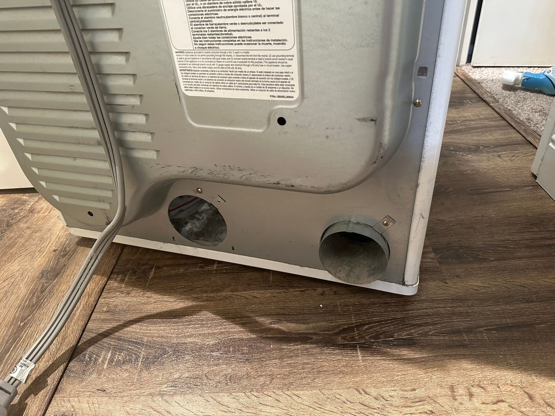 A washer and dryer are sitting on a wooden floor.