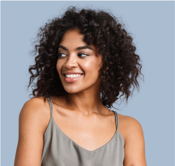 A woman with curly hair is smiling and wearing a tank top.