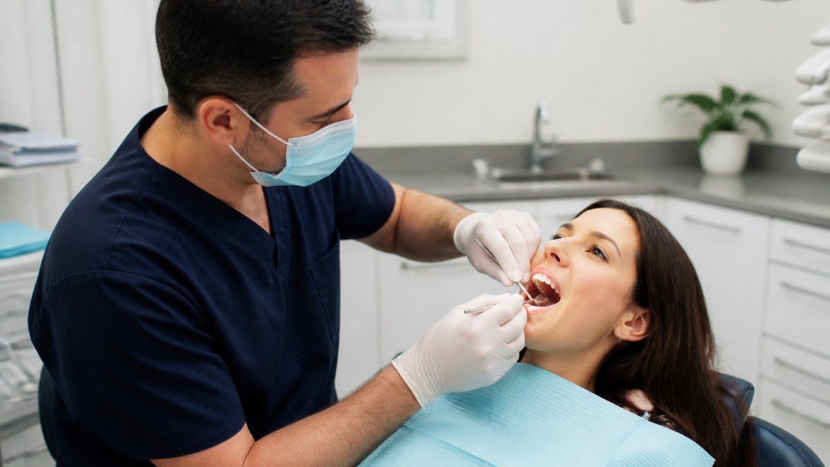 Dentist performing a professional oral checkup during a patient's first dental exam in a modern clinic.