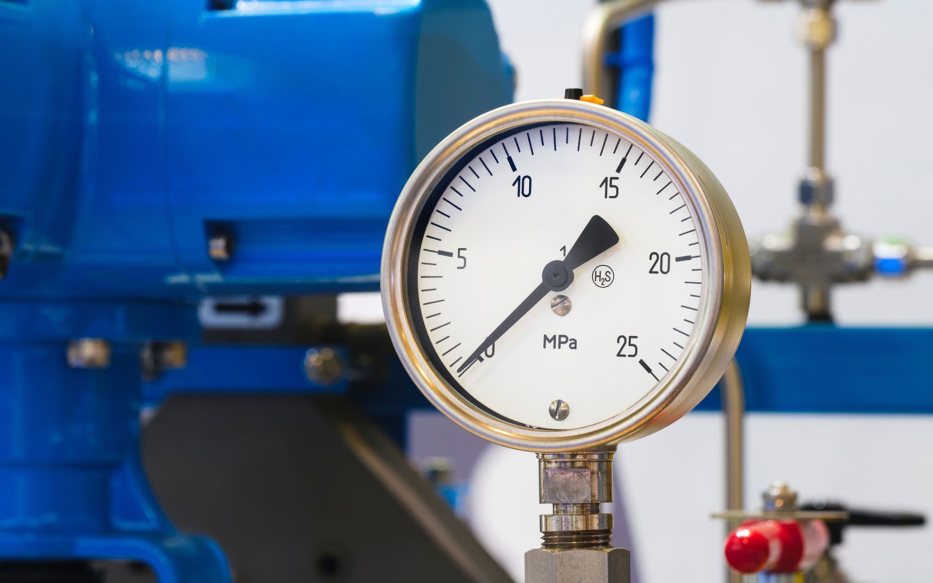 A close up of a pressure gauge in a factory.