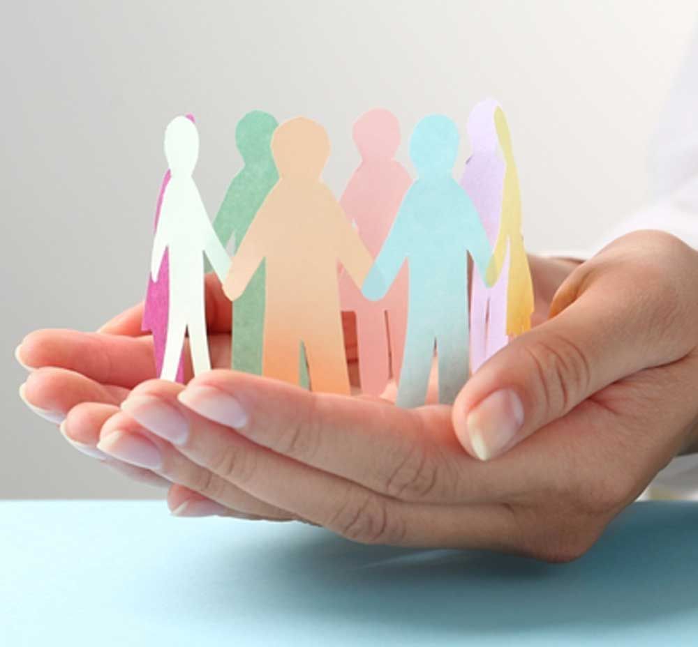 A Person Is Holding a Group of Paper People in Their Hands — Active Ables Community Services In Tamworth, NSW
