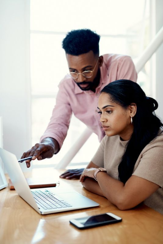 A Man and A Woman Are Looking at A Laptop Computer — Active Ables Community Services In Tamworth, NSW