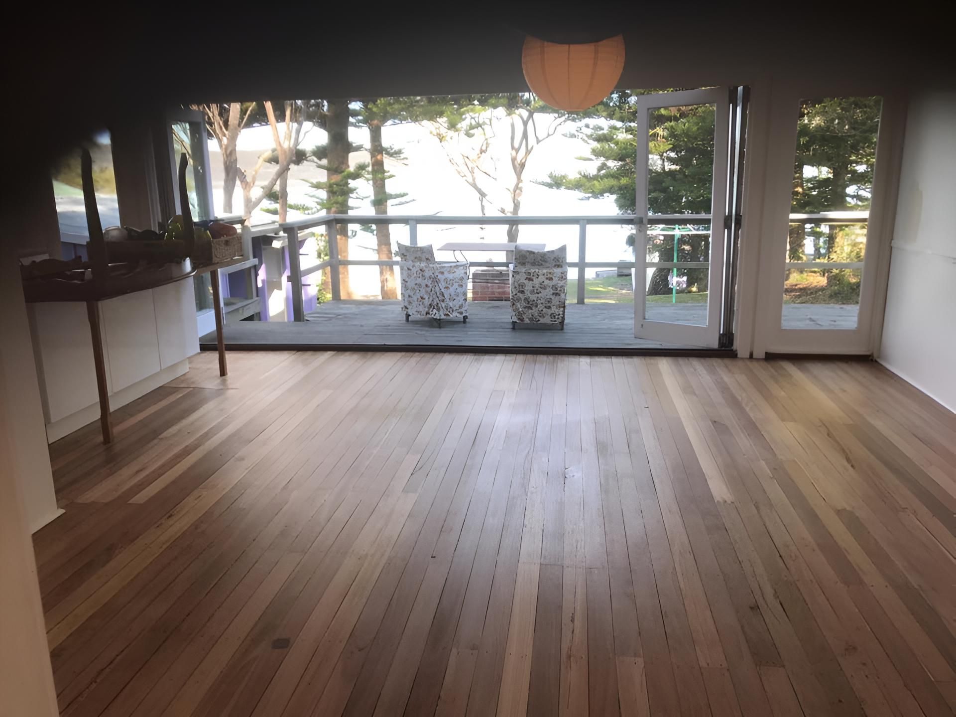 A Living Room With A Wooden Floor And Sliding Glass Doors — Coolangatta Floor Sanding In Shoalhaven Heads, NSW