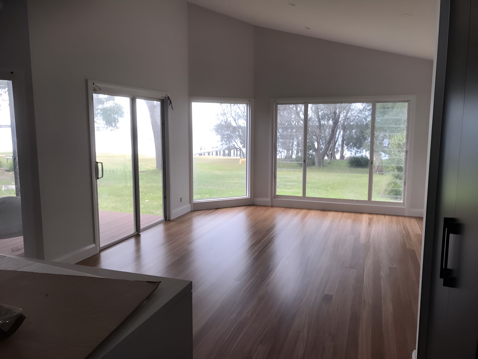 An Empty Living Room With Hardwood Floors And Lots Of Windows โ Coolangatta Floor Sanding In Shoalhaven Heads, NSW