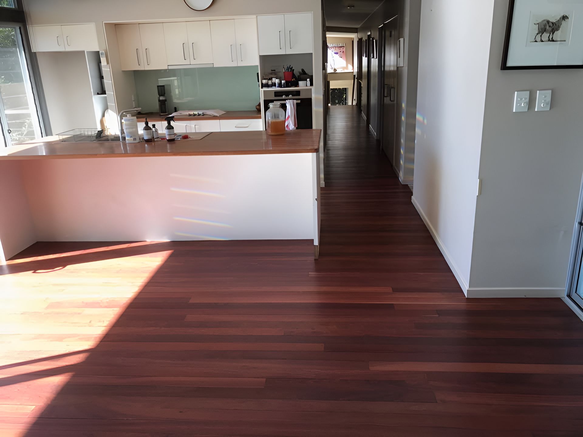 A Kitchen With A Wooden Floor And White Cabinets โ Coolangatta Floor Sanding In Shoalhaven Heads, NSW