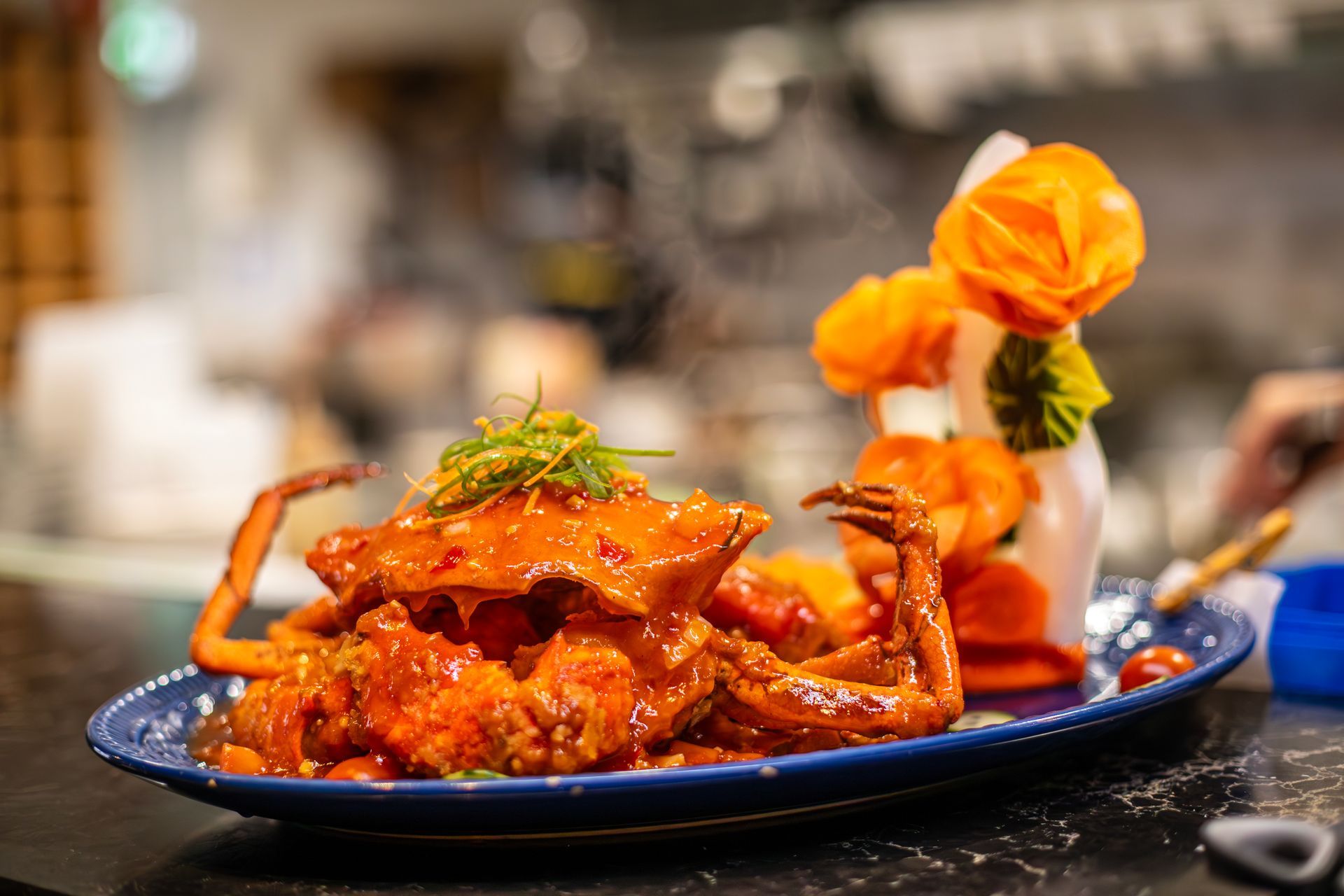 A close up of a plate of food with a crab on it on a table.