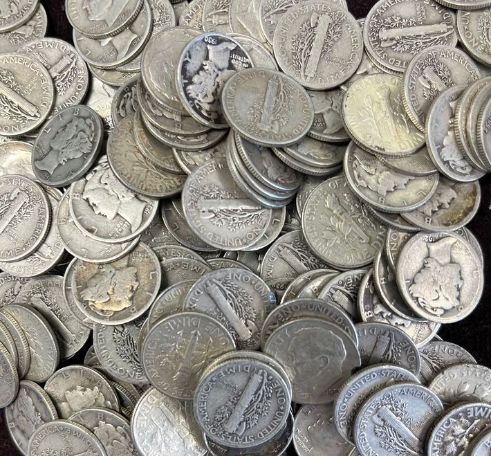 A wooden table with coins and bracelets on it A wooden table with coins and bracelets on it