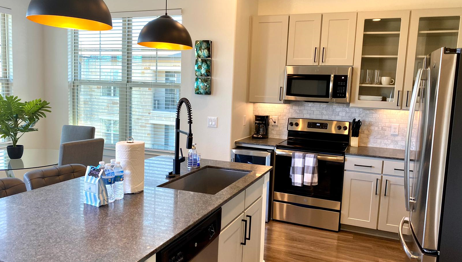 A kitchen with stainless steel appliances and granite counter tops.