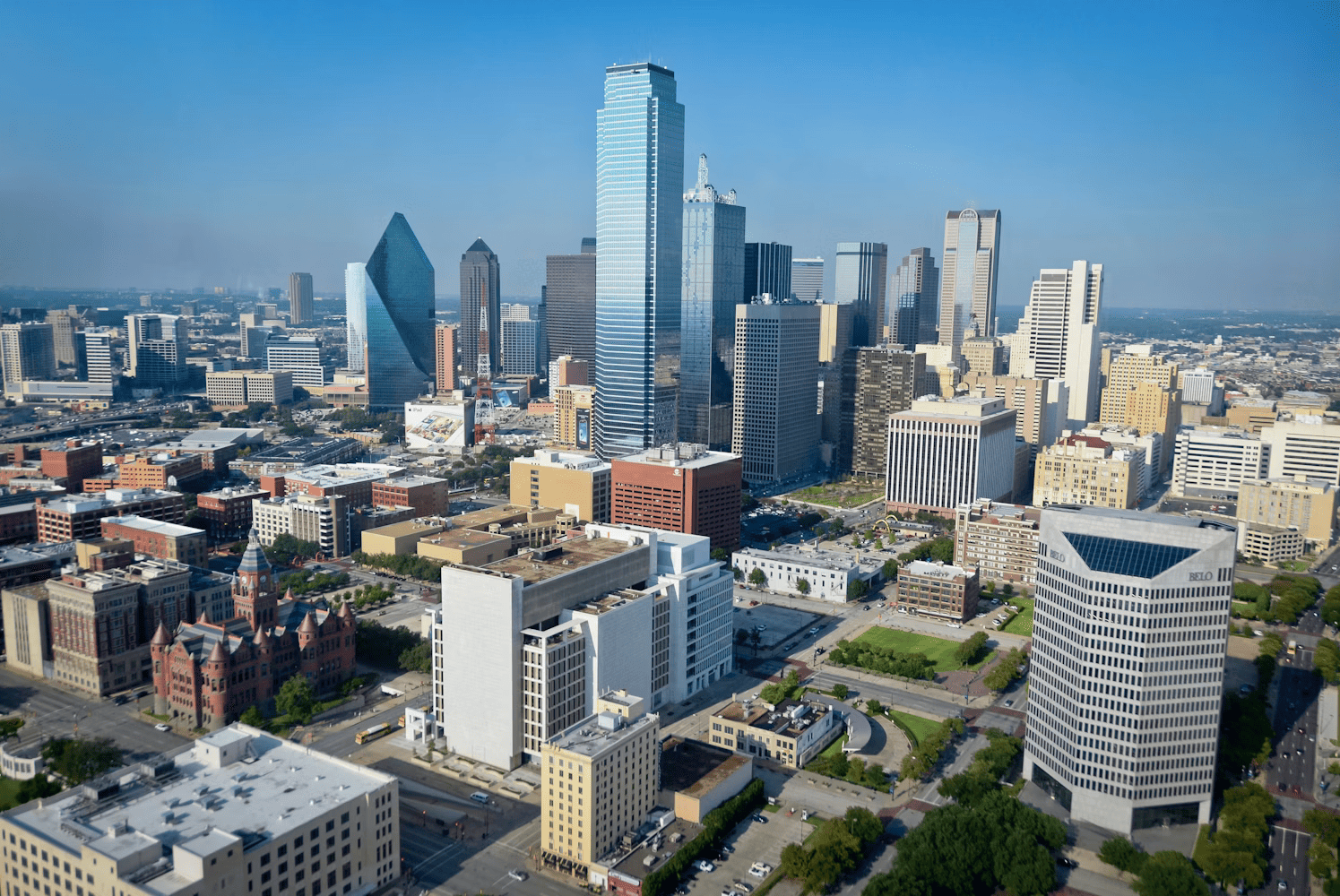 Aerial view of the Dallas skyline featuring the Bank of America Plaza, Fountain Place, and surrounding city buildings.