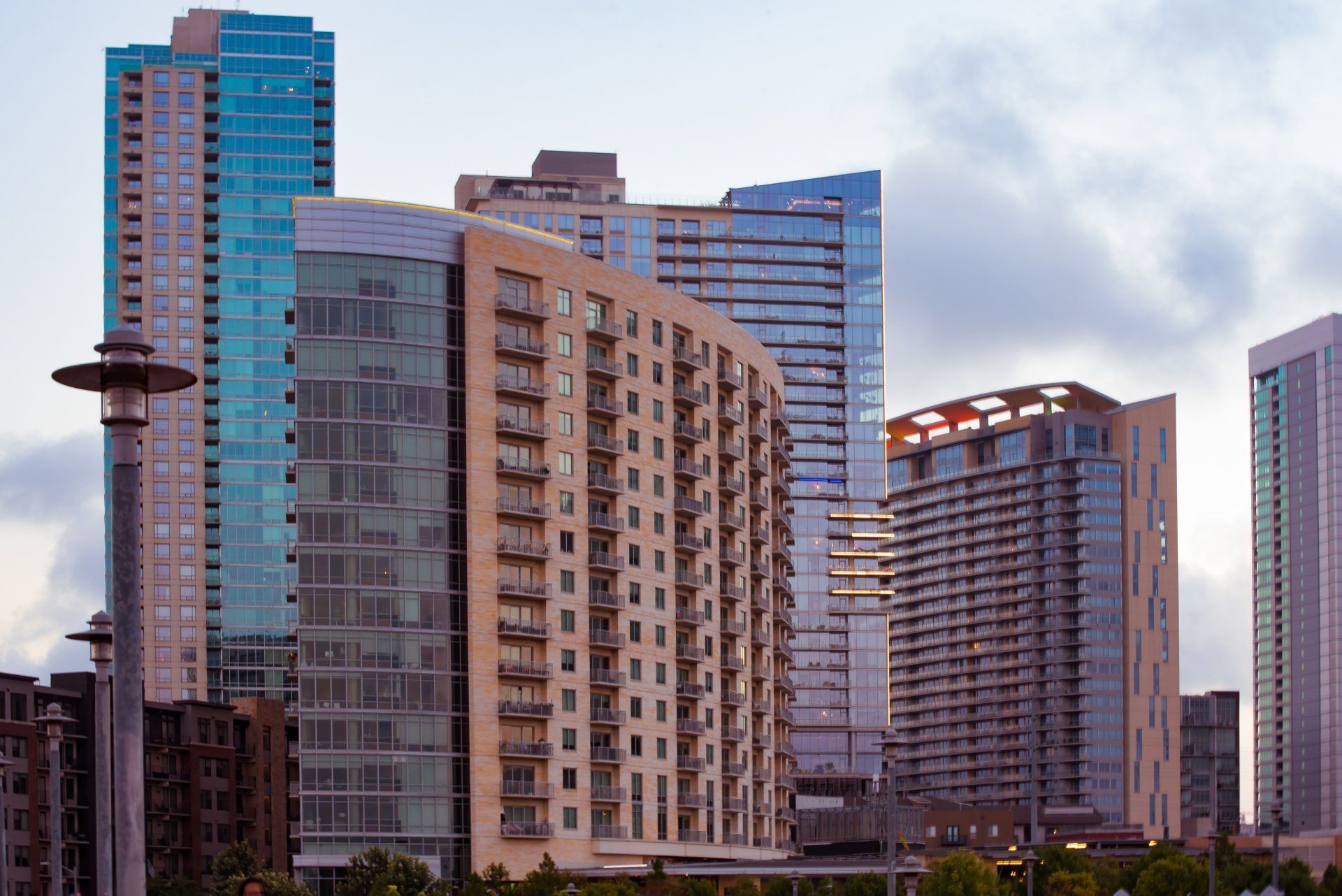A city skyline with a lot of tall buildings and a street light in the foreground.