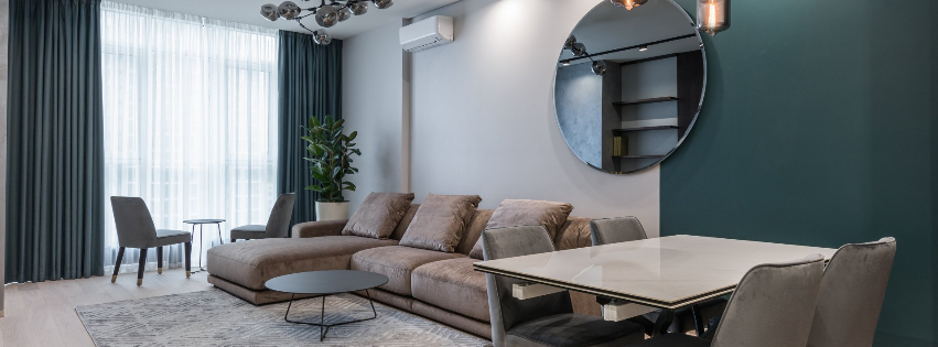 A living room with a couch , table , chairs and a mirror.