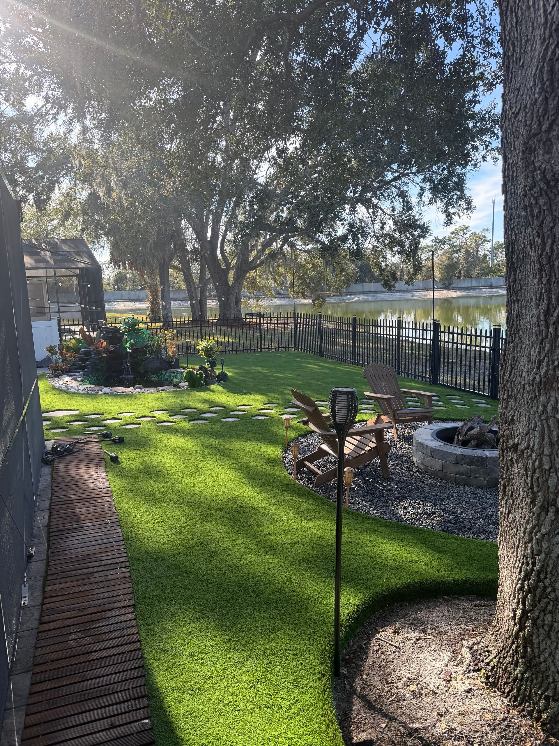 Rolled-up artificial turf, in varying shades of green, sits on top of a patch of artificial grass.